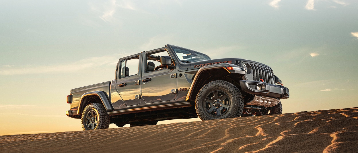 2020 Jeep Gladiator parked on top of sand hill in a desert