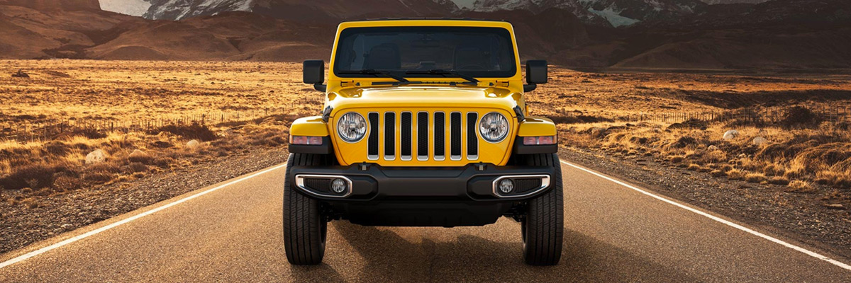 A head-on view of the 2021 Jeep Wrangler Sahara against a mountain backdrop.