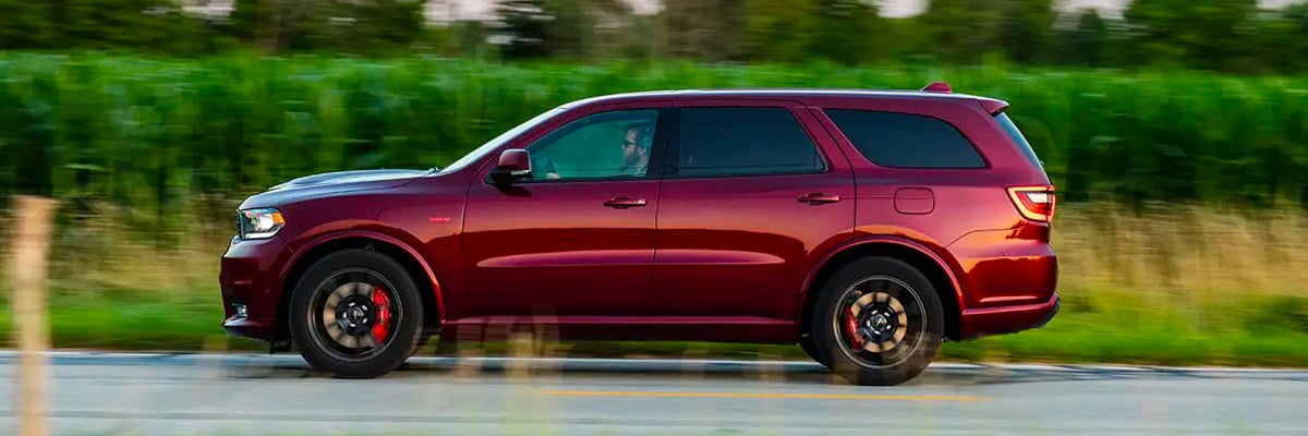 The 4xe logo. The 2022 Jeep Grand Cherokee Trailhawk 4xe being driven through a mud puddle.