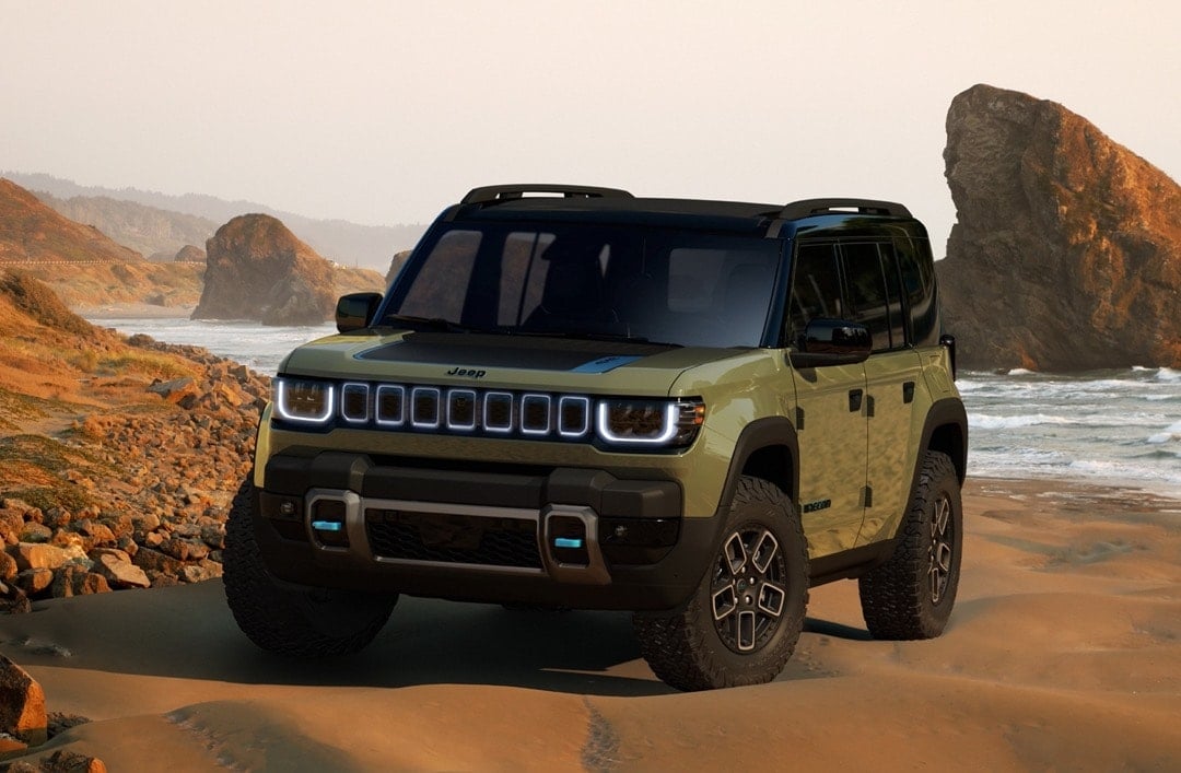 Front 3/4 view of Jeep Recon parked on sand.