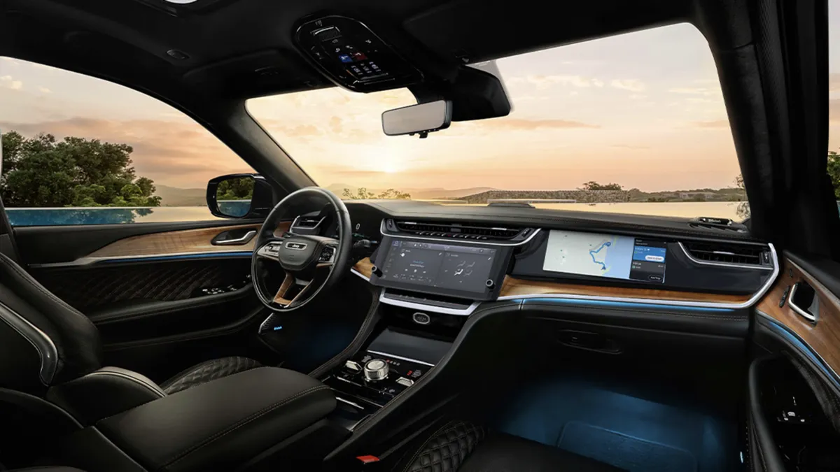 Interior view of the 2026 Jeep Grand Cherokee with the dashboard, center screen and panoramic sunroof.