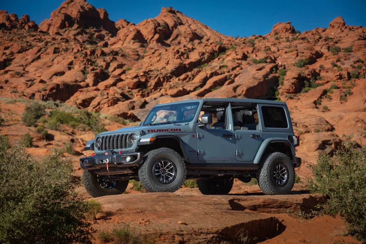 Three-quarter front view of the Jeep Wrangler parked on a large rock.