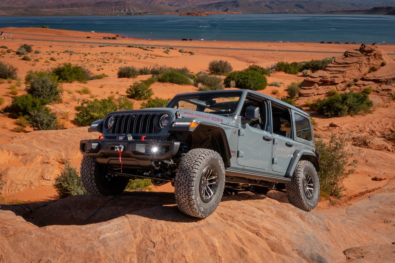 The 2026 Jeep Wrangler driving over large rocks.