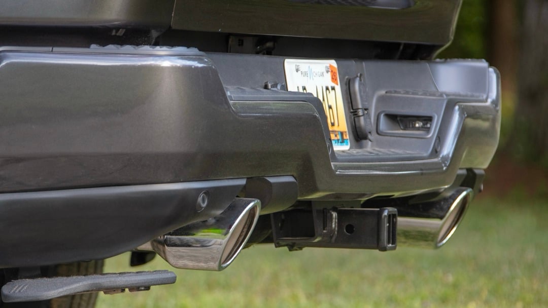 Gros plan sur l’attelage arrière d’un Ram 1500 2026 avec connecteurs de remorque et pare-chocs chromé.
