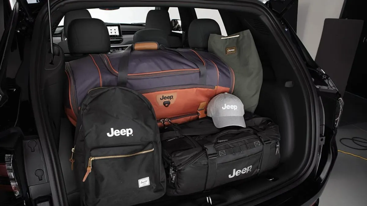 Rear cargo area view of a 2026 Jeep Compass with bags and Jeep gear packed in the back.